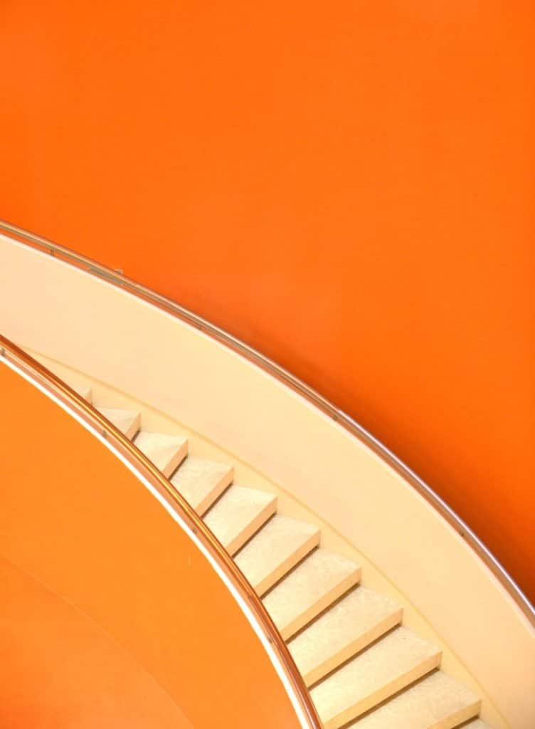 an orange background with light cream stairs.