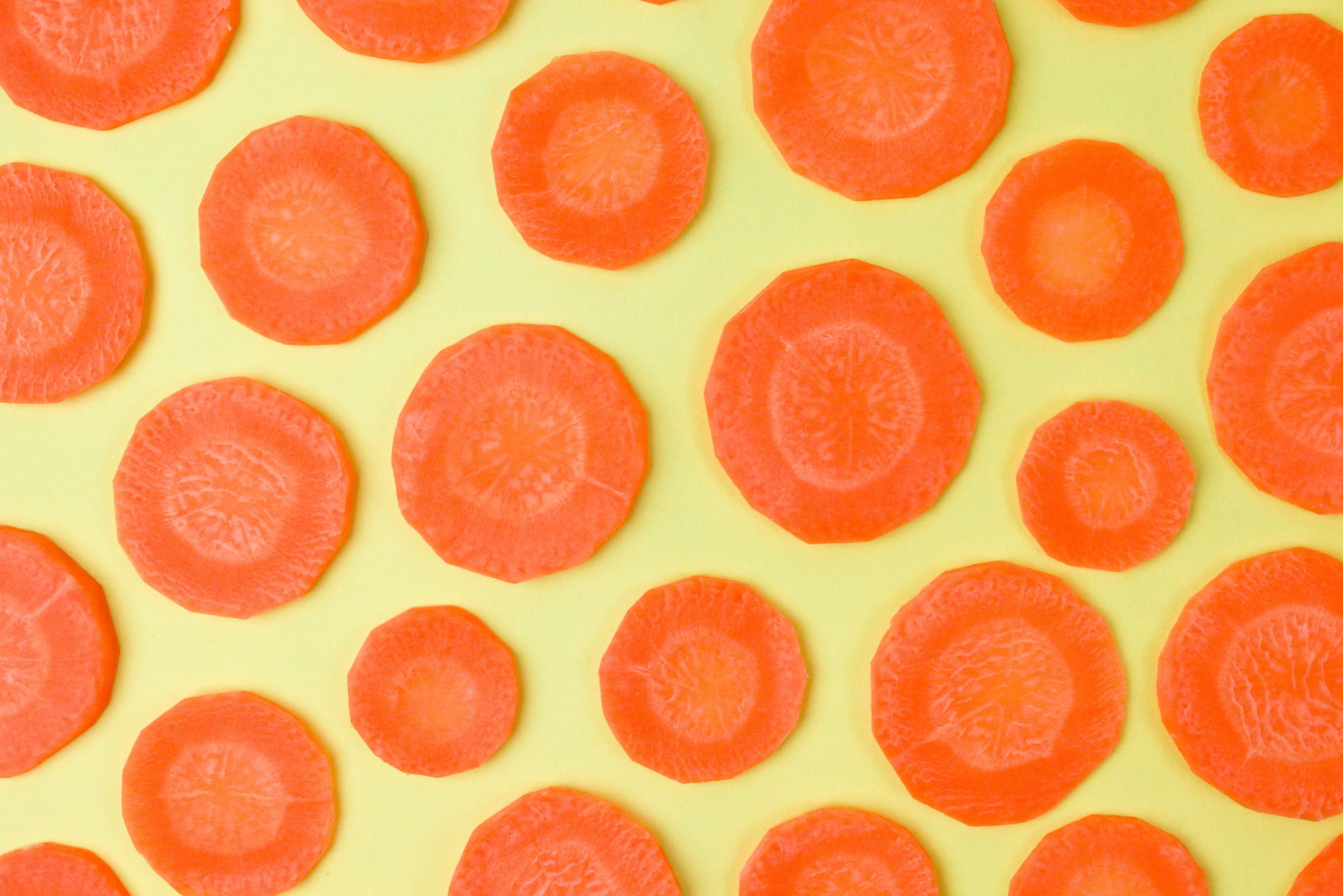 Carrot slices on a yellow table