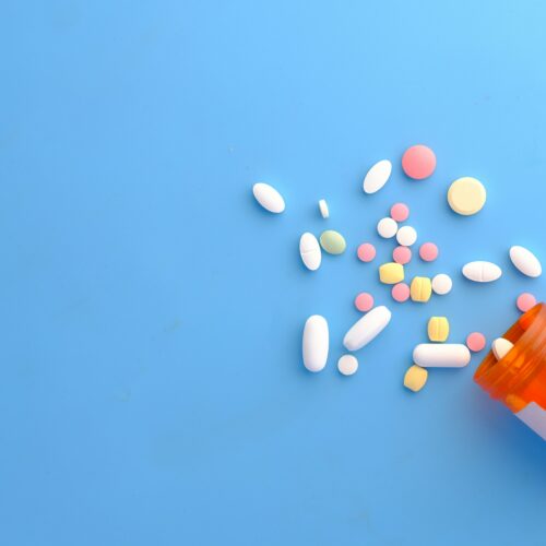 Pills falling out of an orange tub